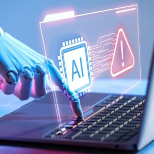 Robotic hand interacting with a laptop, holographic AI chip and a red warning icon signaling an AI security alert.