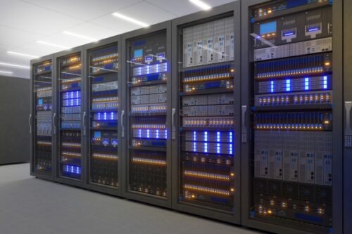 Row of tall server racks in a data center with blue and amber indicator lights and cabling visible on shelves