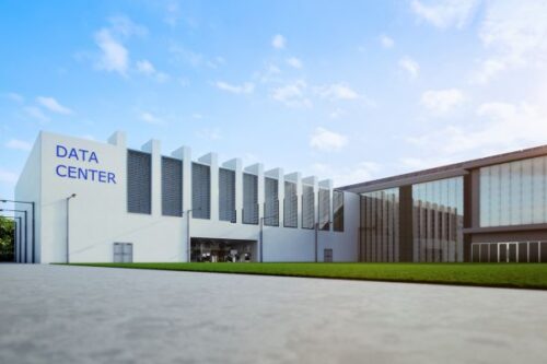 Data center building with a white facade and blue 'DATA CENTER' sign under a blue sky.