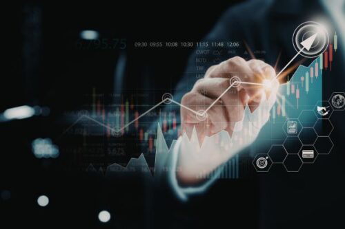 Businessperson's hand interacts with a glowing line chart and hexagonal data icons, signaling financial growth.