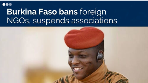 News banner with the headline 'Burkina Faso bans foreign NGOs, suspends associations' over a photo of a smiling soldier in camouflage wearing a red beret and headset, indicating a news article about security or government actions.