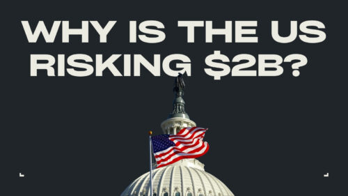 Banner-style image asking, 'Why is the US risking $2B?' over a dark background with a Capitol dome and waving American flag beneath it.
